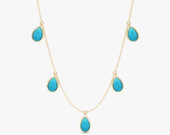May include: A delicate gold necklace featuring five teardrop-shaped turquoise pendants. The pendants are suspended from a fine gold chain, creating a minimalist and elegant design. The turquoise stones have a vibrant, bright blue color.