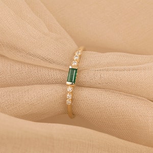 thin 14k gold ring with baguette-cut emerald and natural diamonds