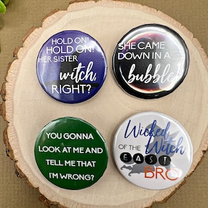 May include: Four round buttons with different Halloween-themed designs. The first button is purple with a black witch silhouette and the text "HOLD ON! HOLD ON! HER SISTER witch RIGHT?" The second button is black with a white moon and the text "SHE CAME DOWN IN A bubble". The third button is green with the text "YOU GONNA LOOK AT ME AND TELL ME THAT I'M WRONG?" The fourth button is white with a black witch silhouette and the text "Wicked OF THE EAST Witch BRO".