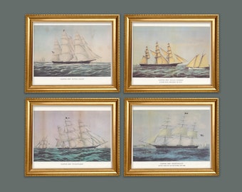 May include: Four framed vintage clipper ship prints. Each print features a different sailing ship on the ocean, with white sails and gold frames. The prints have text at the bottom. The background is a muted blue and gray.
