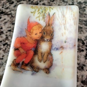 Fused glass spoon rest for kitchen. Elf and bunny image on white glass. RedQueenArtGlass.