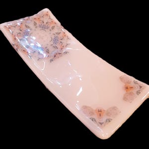 Fused glass spoon rest for kitchen. Kaleidoscope pattern image on almond glass. RedQueenArtGlass.