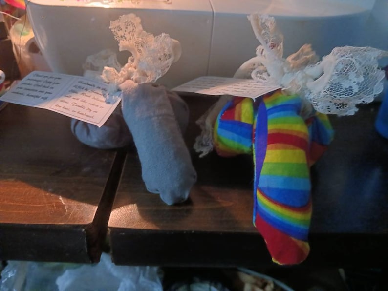 May include: Two fabric sachets with lace trim. One is gray and the other is rainbow striped.