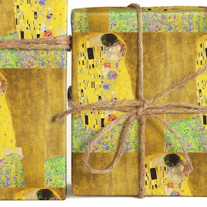 May include: Two gift boxes wrapped in paper featuring Gustav Klimt's "The Kiss" artwork. The boxes are tied with twine. The wrapping paper has a gold background with the painting's figures in yellow, gold, and colorful accents.