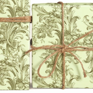 May include: Two gift boxes wrapped in green and white floral patterned paper with brown twine tied around them.