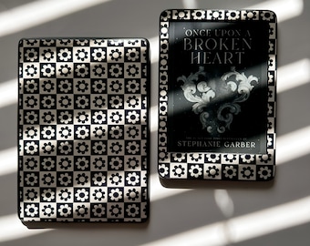 May include: Two black and white e-readers with a checkered pattern on the front. The e-reader on the right has the title "Once Upon a Broken Heart" by Stephanie Garber.