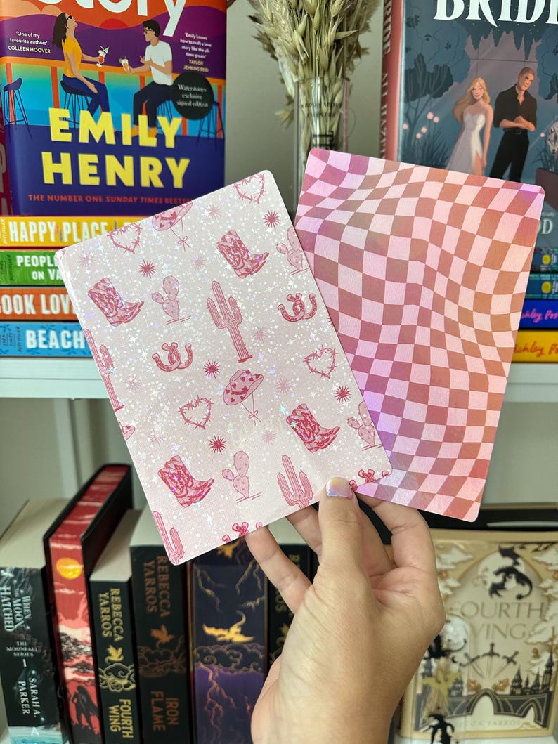 May include: Two pink and white patterned cards. One card has a pink and white checkered pattern. The other card has a pink and white pattern with cacti, stars, and cowboy boots.