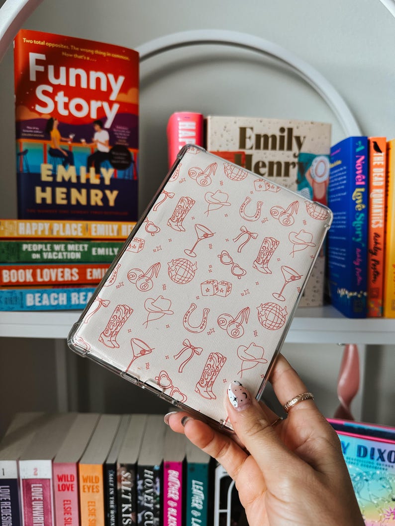 May include: A clear phone case with a white background and a red pattern of cowboy boots, hats, horseshoes, dice, and martini glasses.