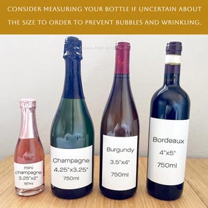 May include: Four wine bottles of varying sizes and shapes are displayed on a wooden surface. The bottles include mini champagne, champagne, burgundy, and bordeaux. Each bottle has a label with measurements in inches and volume in milliliters or 750ml.