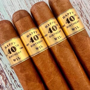 May include: Four brown cigars with gold labels that say "Happy 40th Birthday Wil Est 1984"