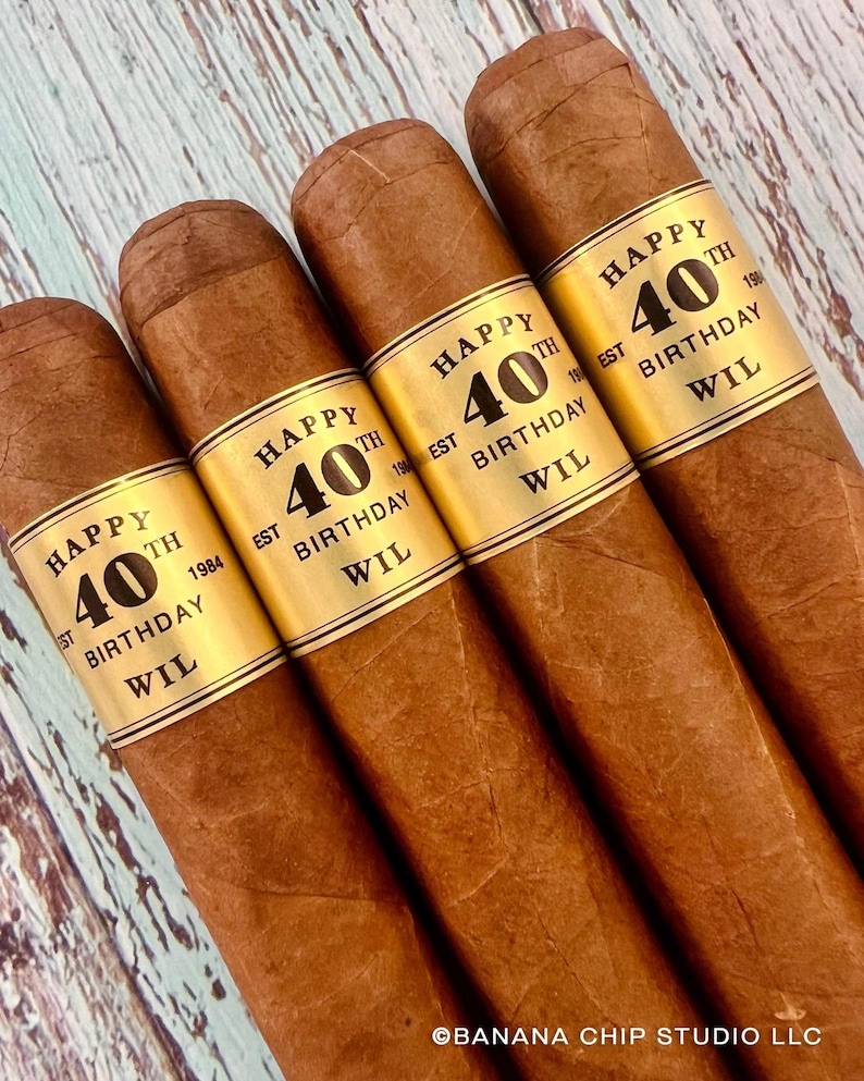 May include: Four brown cigars with gold labels that say "Happy 40th Birthday Wil Est 1984"