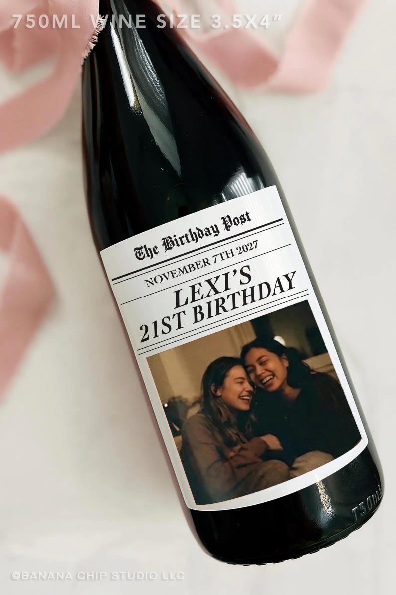 May include: A dark wine bottle with a custom label. The label reads "The Birthday Post" and "Lexi's 21st Birthday" with a photo of two smiling people. The bottle is 3.5 x 4 inches and holds 750ml of wine.