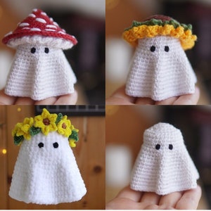May include: Four crocheted ghost amigurumi toys with different hats. The first ghost has a red and white mushroom hat, the second has a yellow and green flower crown, the third has a brown and yellow flower crown, and the fourth has no hat.