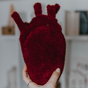 May include: A crocheted heart-shaped plush toy in a deep burgundy color.