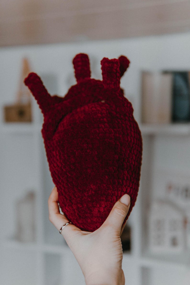 May include: A crocheted heart-shaped plush toy in a deep burgundy color.