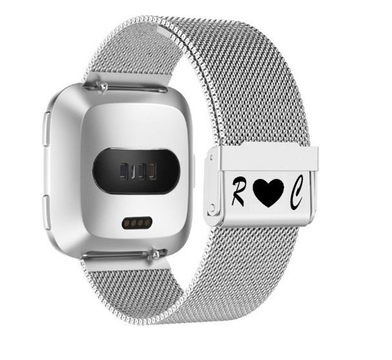 May include: A silver smartwatch with a mesh band. The watch face is rectangular with a black display. The band clasp features the letters "R" and "C" flanking a black heart symbol.