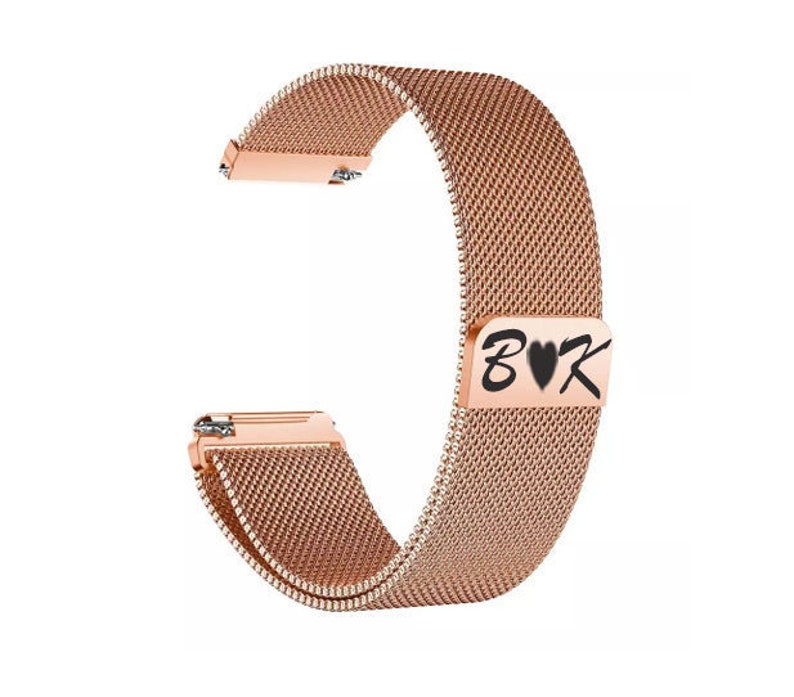 Puede incluir: Correa de reloj de oro rosa con dise&ntilde;o de malla. La correa tiene un cierre magn&eacute;tico con las letras "B&hearts;K" en negro. La correa est&aacute; hecha de un material met&aacute;lico tejido y tiene un acabado brillante.