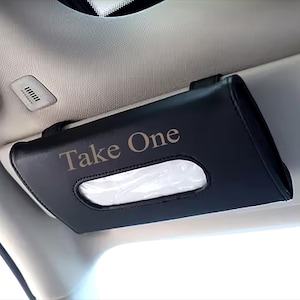May include: Black leather car tissue holder with a clear plastic window and the text "Take One" embossed in gold.