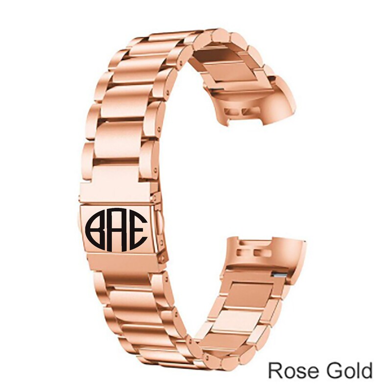 K&ouml;nnte beinhalten: Armband aus ros&eacute;goldfarbenem Metall mit einer monogrammierten Schlie&szlig;e, auf der "BAE" steht.