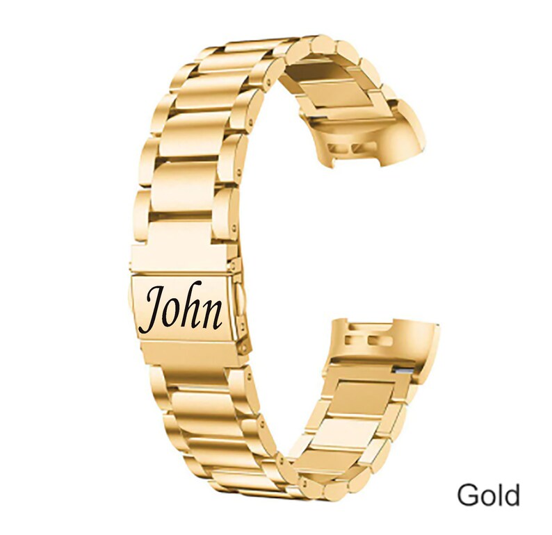 K&ouml;nnte beinhalten: Goldenes Metall-Armband mit einer personalisierten Gravur mit dem Text "John".