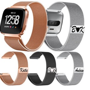 Puede incluir: Una colecci&oacute;n de correas de reloj de malla en oro rosa, plata y negro. Una correa est&aacute; sujeta a un reloj inteligente que muestra la hora y la frecuencia card&iacute;aca. Varias correas presentan texto personalizado: "B&hearts;K", "Katie" y "Andrew".