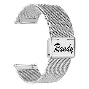 May include: A silver stainless steel watch band with a mesh design. The band features a rectangular clasp with the name "Randy" in black script. The band is designed to attach to a watch face.