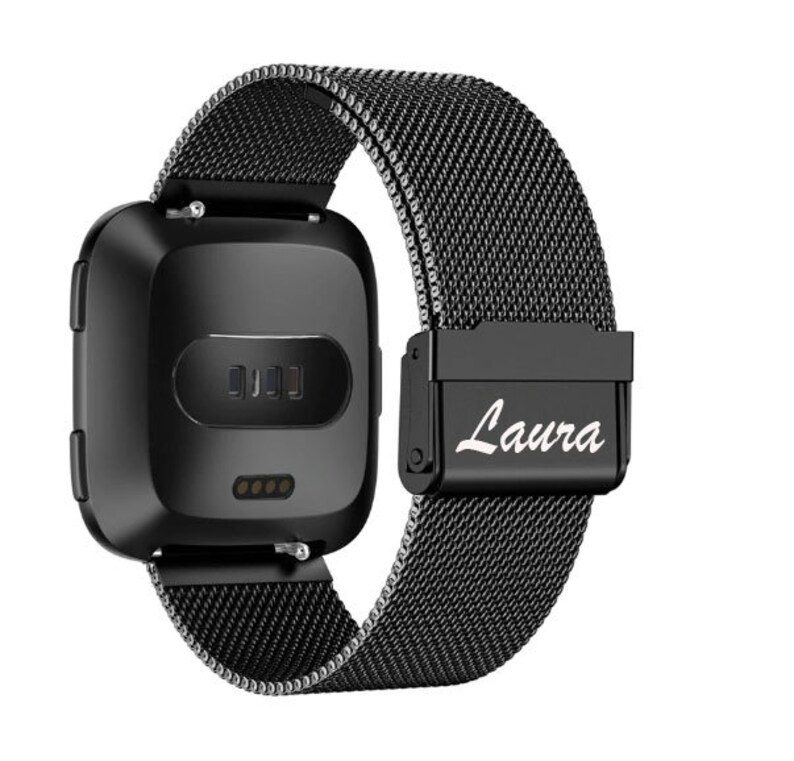 May include: Black smartwatch with a mesh band. The watch face is square with rounded corners. The band has a magnetic clasp with the name "Laura" in white script. The watch is designed for fitness tracking and notifications.
