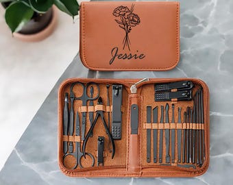 May include: A brown leather travel case with the name "Jessie" engraved on the front. The case is open to reveal a set of black manicure tools, including nail clippers, tweezers, and a file.