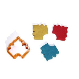 May include: Four cookie cutters, one shaped like a tree, one yellow, one red, and one blue.