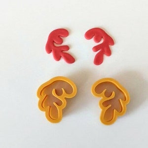 May include: Two red and two yellow plastic cookie cutters shaped like reindeer antlers.