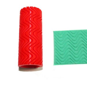 May include: A red rubber roller with a wavy pattern and a green rubber sheet with the same wavy pattern.