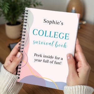 May include: A spiral-bound notebook titled "Sophie's COLLEGE survival book." The cover is light pink with teal and light blue text and abstract pastel shapes. The text "Peek inside for a year full of fun!" is also visible.