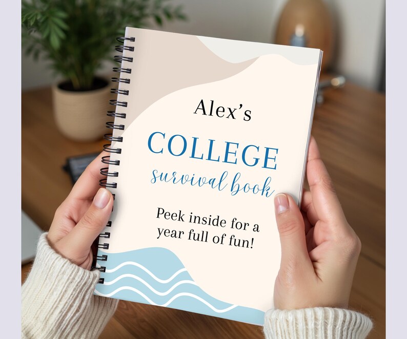 May include: A spiral-bound notebook titled "Alex's COLLEGE survival book" with blue and beige accents. The cover includes the text "Peek inside for a year full of fun!" The notebook is held by a person wearing a cream-colored sweater.