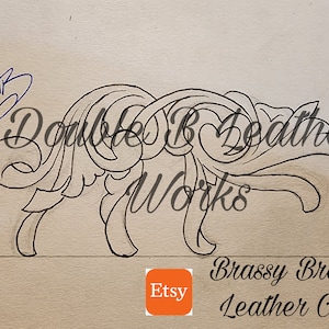 Può includere: Un disegno in bianco e nero di un motivo floreale. Il disegno è intricato e dettagliato, con una varietà di curve e volute. Il disegno è su uno sfondo marrone chiaro. Il testo "Double B Leather Works" è scritto in corsivo nella parte superiore del disegno. Il testo "Brassy Brod Leather Co." è scritto in corsivo nella parte inferiore del disegno. Il testo "Etsy" è scritto in un riquadro quadrato nell'angolo inferiore sinistro del disegno.