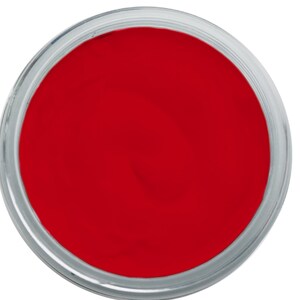 May include: A round container filled with bright red paint. The paint is smooth and evenly distributed within the clear, circular container. The container has a silver rim and is set against a white background.