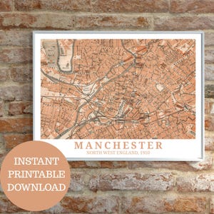 May include: Framed vintage map print of Manchester, North West England, from 1910. The map is in shades of orange and brown, with detailed streets and landmarks. The words "Manchester" and "Instant Printable Download" are also visible.