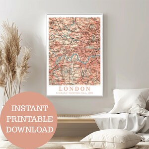 Op de afbeelding: Een ingelijste vintage kaart van Londen, Engeland, uit 1908, in roze en beige tinten, met de tekst "LONDON" en "INSTANT PRINTABLE DOWNLOAD". De kaart toont de rivier de Theems in blauw.