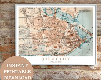 May include: Framed vintage map print of Québec City, Canada, from 1922. The map shows detailed street layouts, water features, and landmarks in shades of brown, beige, and blue. The words "QUÉBEC CITY CANADA, 1922" are printed below the map.