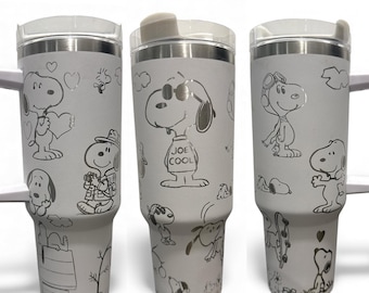 Puede incluir: Tres vasos aislados blancos con bordes y tapas de acero inoxidable. Cada vaso presenta un diseño diferente de Snoopy, con varias ilustraciones de Snoopy en diferentes poses. Un vaso tiene el texto "JOE COOL".