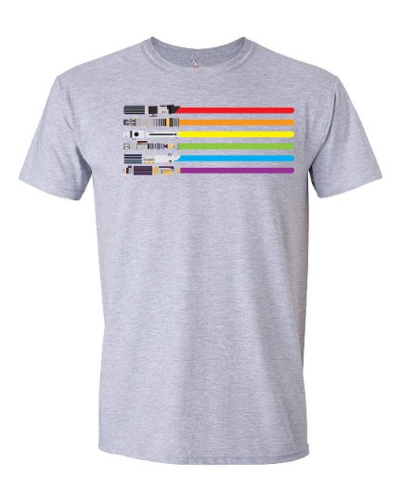 K&ouml;nnte beinhalten: Ein graues T-Shirt mit einem Regenbogenmuster aus Lichtschwertern. Die Lichtschwerter sind horizontal angeordnet, wobei das rote Lichtschwert oben und das violette Lichtschwert unten ist.