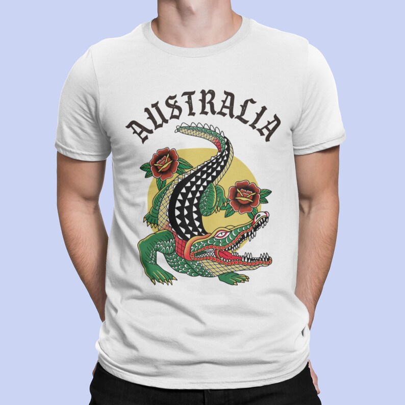 May include: White t-shirt with a green and black crocodile illustration and the word "AUSTRALIA" in black lettering.