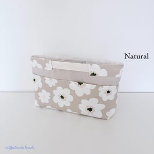 May include: A rectangular fabric organiser insert featuring a beige background with a repeating white flower pattern. The bag has a solid beige horizontal band across the top, a central handle, and multiple exterior pockets. The text Natural is visible.