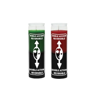 May include: Two glass jar candles. One is green and black, the other is red and black. Each candle has a white label with the text "DOBLE ACCION REVERSIBLE" and a white graphic of a face with an arrow pointing up and down.
