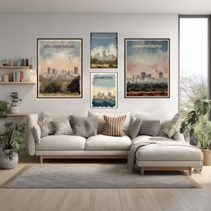 May include: A living room features a white sofa, a gray rug, and framed art prints. The prints, each with a black frame, display watercolor-style cityscapes with the word "JOHANNESBURG" at the top. The color palette includes blues, browns, and greens.