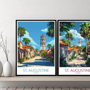 Könnte beinhalten: Zwei gerahmte Kunstdrucke, die eine Straßenszene in St. Augustine, Florida, zeigen. Das Kunstwerk zeigt einen hohen Turm, Palmen und Gebäude mit roten Ziegeldächern unter blauem Himmel. Der Text "ST. AUGUSTINE FLORIDA" befindet sich unten.