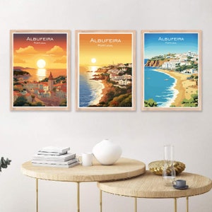 Może przedstawiać: Trzy oprawione wydruki tego samego miasta, Albufeira, w Portugalii. Wydruki przedstawiają różne widoki miasta, w tym zachód słońca nad oceanem, widok miasta ze skał i widok plaży. Wydruki są wszystkie w jasnej drewnianej ramie.