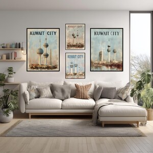 May include: Four framed art prints of Kuwait City are displayed above a white sofa. Each print shows a watercolour-style depiction of the Kuwait Towers, with the words "KUWAIT CITY" at the top. The prints vary in size and orientation.