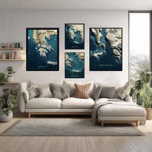 Può includere: Quattro opere d'arte da parete incorniciate raffiguranti mappe topografiche del Mar Adriatico. Le mappe sono in tonalità blu e beige, con la scritta "ADRIATIC SEA". Le cornici nere sono appese sopra un divano bianco.
