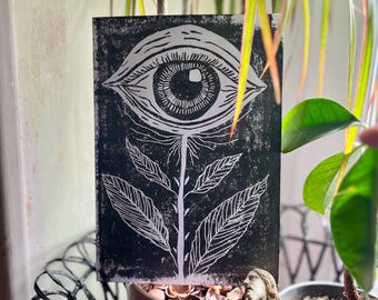 Linograbado impreso a mano con planta y ojo, blanco y negro