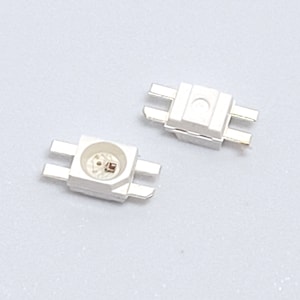 Puede incluir: Dos luces LED blancas con cuatro pines cada una. Las luces son pequeñas y rectangulares, con una lente transparente.